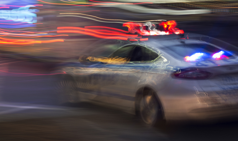 Moving police car with flashing lights.