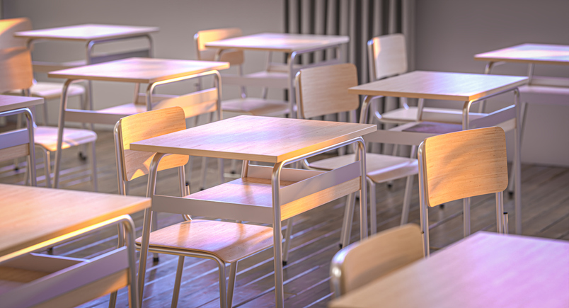 Empty classroom with wooden desks and chairs is waiting for students