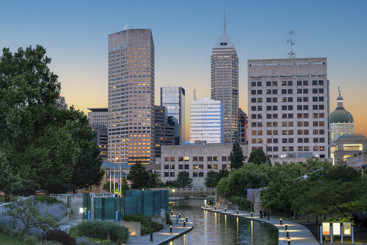 Serene and vibrant view of Indianapolis Canal Walk and skyline featuring tall office buildings, iconic Salesforce Tower, and the Indiana State Capitol dome