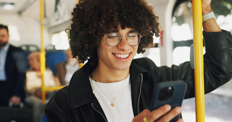 Phone, smile and man on bus online for checking university exam results on mobile app with travel. Cellphone, college and male student reading acceptance email on public transportation in city.